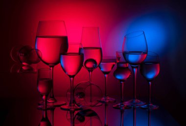 Renkli eğimli arkaplanda cam kadehler