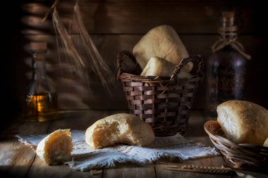 Fresh white bread and a wicker basket on a rustic table