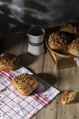 Tahta bir masada ayçiçeği ve kabak çekirdeği ile ev yapımı çörekler.