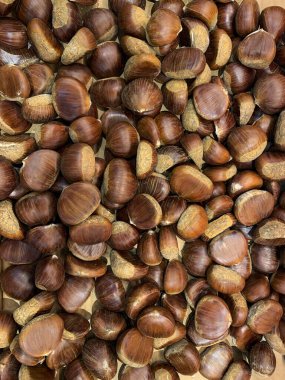 Market arka planında kestaneler tezgahın üzerine saçılmış.