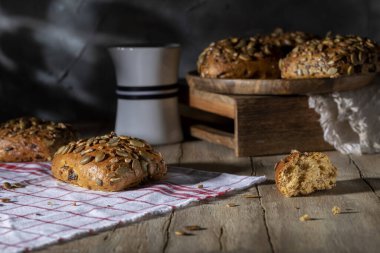 Tahta bir masada ayçiçeği ve kabak çekirdeği ile ev yapımı çörekler.