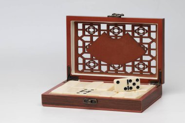 Beyaz arka planda domino oyunu için yontulmuş tahtadan bir kutu.