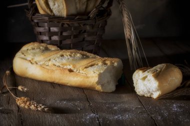 Tahta bir masada kırık taze ekmek.