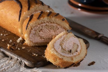 Kesme tahtasının üzerinde çilekli tereyağlı dilimlenmiş rulo