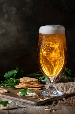 Koyu bir duvara karşı bir bardak bira.