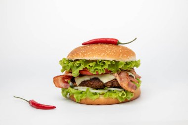 Pastırmalı hamburger ve beyaz arka planda kırmızı biber.