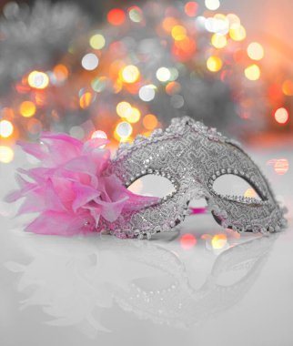 Yüzün üzerine bulanık ışıklarla beyaz bir arka plan yerleştirilmiş bir maske.