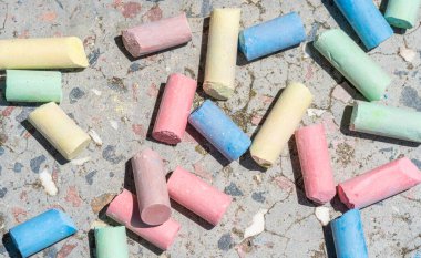 Beton bir levhaya saçılmış kırık renkli tebeşirler.