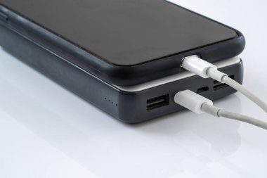Şarj etmek için USB kablosu olan harici bir aküye bağlı bir cep telefonu
