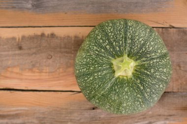 Ahşap masada yeşil kabak arkaplanı