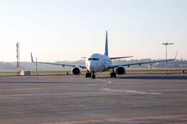 Uzun bir otoparktaki yolcu uçağı küçük bir havaalanında, sabah vakti.