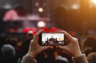 Açık hava yaz konserinin fotoğraflarını ve videolarını akıllı telefondan çekmek.