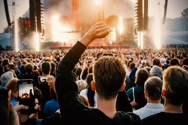 Stock image People with raised hands enjoy music concert