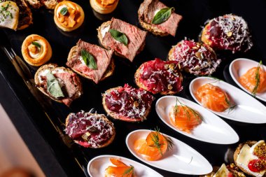 Yemek tabağı. Büfe masasında çeşitli atıştırmalıklar var.