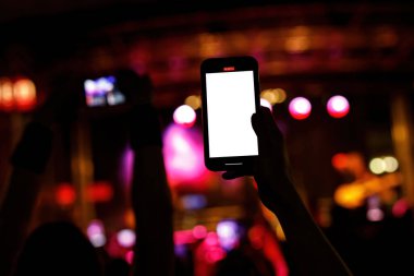 Using a mobile phone at a music concert. Mock-up with a blank screen for your picture
