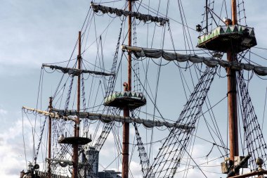 Sailing ship mast with rigging and cables against the sky