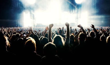 Silhouette of a happy crowd with hands up during a big rock concert