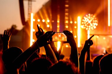 The crowd on a fan zone with the smartphone to record or take pictures during the live concert