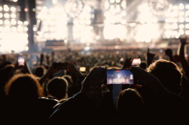 The crowd on a fan zone with the smartphone to record or take pictures during the live concert