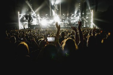 People with mobile phones record a music concert