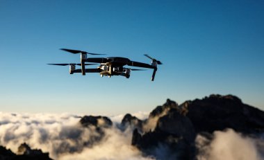 Drone with camera flying over the mountains