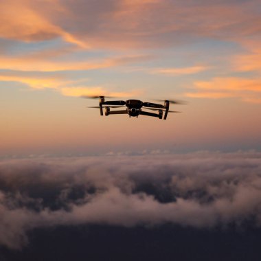 Drone flying over the clouds during the sunset