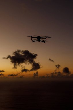 Flying drone in a sunset sky