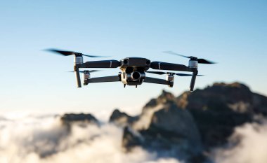 Drone with camera flying over the mountains