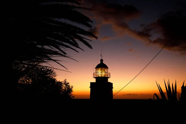 日落时的海洋灯塔 背景上的戏剧性云彩 — 图库照片