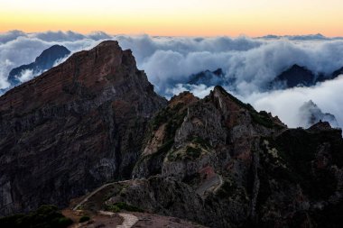 Taş kayalar, dağların tepeleri. Bulutlar ve gün batımı ışık arkaplanı