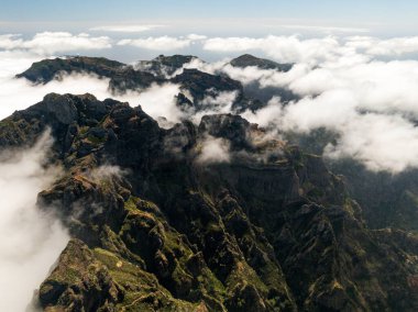Bulutların arasındaki dağların tepeleri, İHA 'nın en üst görüntüsü.
