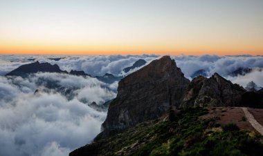 Gün batımında dağ zirveleri. Zirvenin altındaki bulutlar
