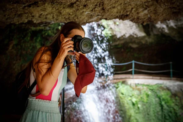カメラを持った女性 マデイラ島を通る人気のある観光コースの石窟内の写真家 — ストック写真