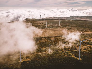 Rüzgar türbinleri yeşil enerji için rüzgarlı bir yerde yüksek dağlarda bulutların üzerinde