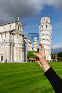Seyahat fotoğrafçılığı: Turist akıllı telefon kullanarak ünlü eğimli Pisa Kulesi 'nin fotoğraflarını çekiyor