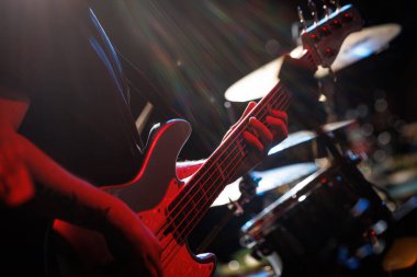 Bas gitaristin parmakları gitar panosunda. Yakın plan.