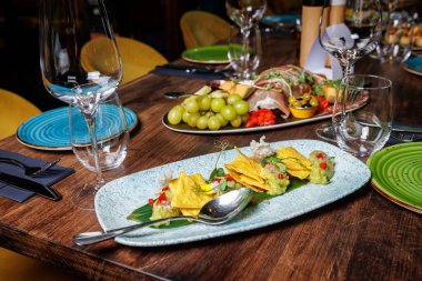 Restoranda bir tabakta mısır cipsi ile guacamole.