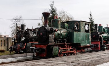 Retro lokomotif, buharlı tren açık hava deposuna park edilmiş.