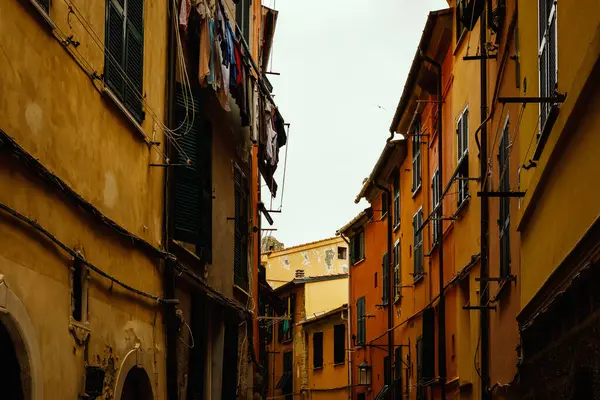 イタリアの町の狭い伝統的な通りにある黄色と赤の明るい家 ロイヤリティフリーのストック画像