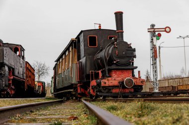 Retro lokomotif, buharlı tren açık hava deposuna park edilmiş.
