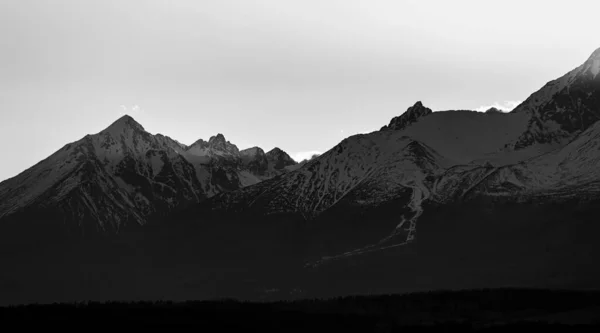 雪は山の頂上 黒と白を覆いました ストック写真