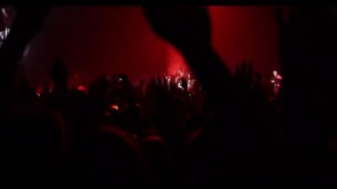 Konser salonundaki mutlu kalabalık. Kaldırılmış ellerin siluetleri