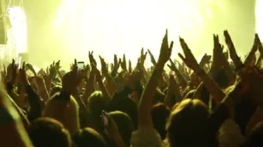 Konser salonundaki mutlu kalabalık. Kaldırılmış ellerin siluetleri