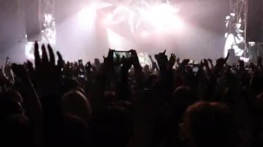 Konser salonundaki mutlu kalabalık. Kaldırılmış ellerin siluetleri