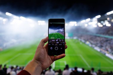 Futbol fanatiği akıllı telefon kamerasıyla oyunun fotoğrafını çekiyor