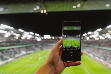 Stadyumun içindeki bir futbol maçının akıllı telefon fotoğrafını çekiyorum.
