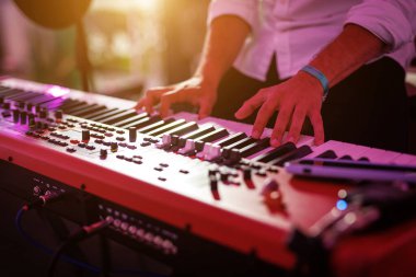Yakın plan: Bir Rock grubundan bir piyanistin veya klavyecinin elleri Sentezleyici Çalıyor