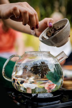 Çay ustası demlenmek için çaydanlığa yaprak koyar..
