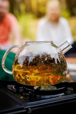 Şeffaf bir çaydanlık elektrikli bir ocakta ısıtılır. Çay kaynıyor.