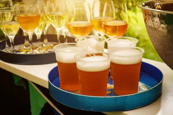 The set of plastic beer glasses on a tray